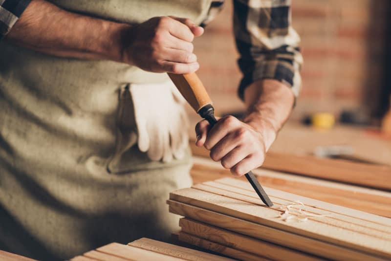 Homme qui travaille le bois avec un outil à main