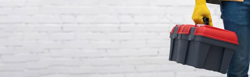 Zoom sur un bricoleur qui tient son materiel